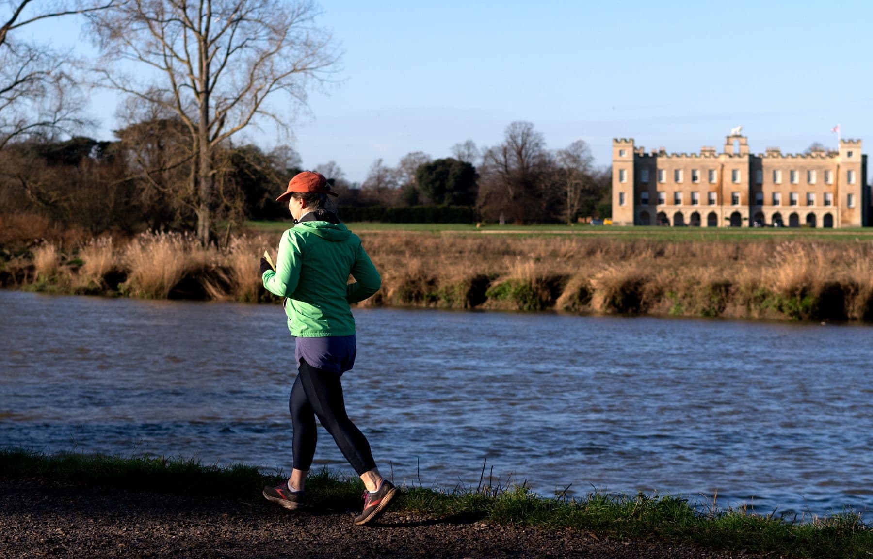 A person jogging beside a river